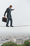 businessman walking across a tightrope