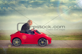senior man driving a toy racing car