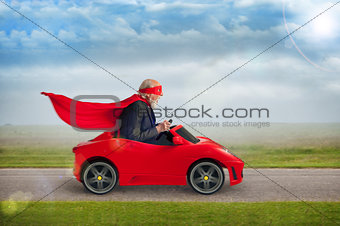 senior superhero driving a toy sports car