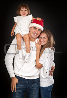 Father in santa hat holding little girl on his shoulder and hugg