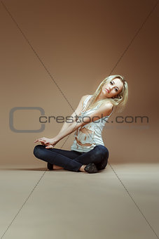 Very Expressive blonde girl in a white torn top and jeans sit on
