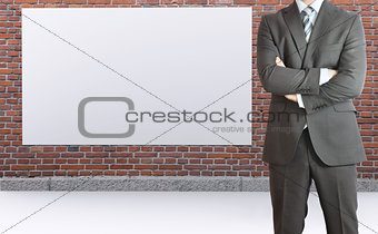 Businessman and brick wall with white placard