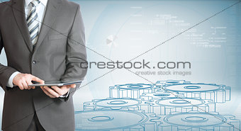 Businessman hold tablet pc. Gears and graphs