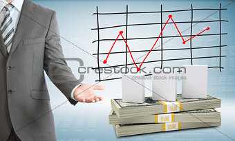 Businessman points hand on white boxes and money