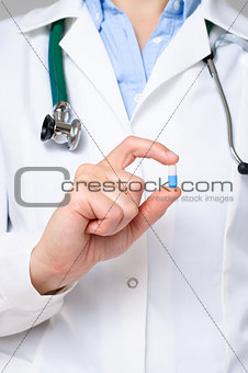 Doctor holding a blue a pill