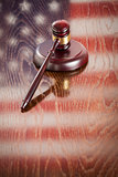 Wooden Gavel Resting on Flag Reflecting Table