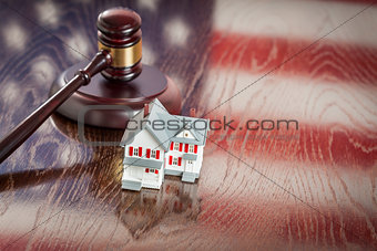 Small House and Gavel on Table with American Flag Reflection