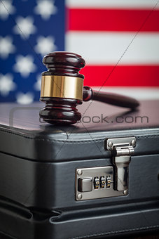 Briefcase and Gavel Resting on Table with American Flag Behind