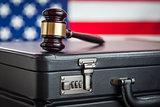 Briefcase and Gavel Resting on Table with American Flag Behind