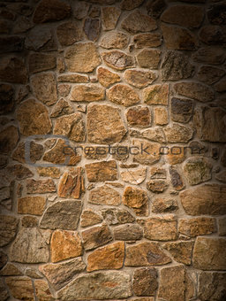 Brown masonry rock wall lit dramatically 