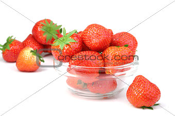 Red strawberries in transparent plate on white