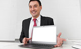 Smiling businessman with blank laptop screen