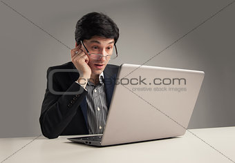 surprised businessman in office working on his laptop