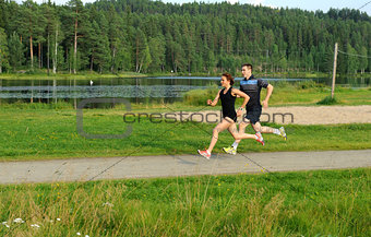 Young couple running outside in summer in the nature