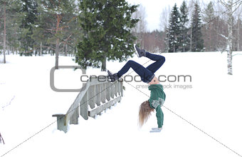 Girl performs gymnastic exercise in the fresh air in winter