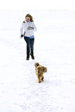 Girl walking in winter with spaniel on a lake