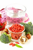 dried goji berries, water, nuts and fresh vegetables for a healthy diet