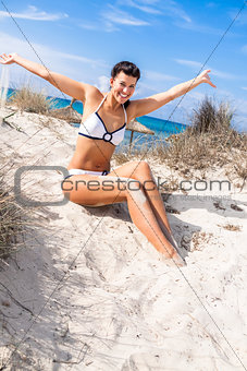 Beautiful woman sitting on golden beach sand