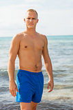 Man in blue swim shorts in the beach