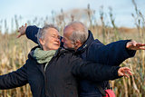 Elderly couple embracing and celebrating the sun