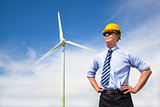professional young engineer standing with wind generator 