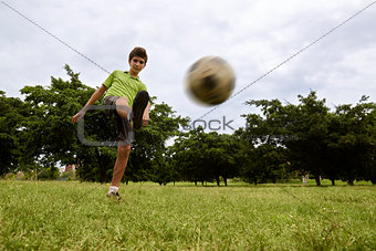 Kid playing football and soccer game in park