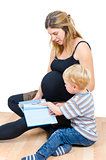 Beautiful pregnant happy mother with child boy reading book isol