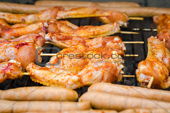 Sausages and chicken wings on smoking grill barbeque