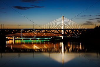 Highlighted bridge at night and reflected in the water