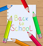 Back to school message with pencils on paper sheet background