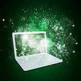 Open laptop with magic light and falling stars