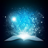 Old open book with magic light and falling stars