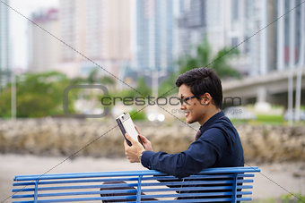 Portrait of asian office worker with ipad on bench