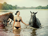  girl bathe horse in a river 