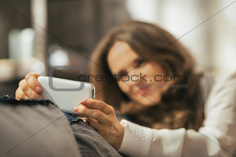 Closeup on young woman writing sms in loft apartment