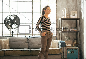 Young woman standing in loft apartment