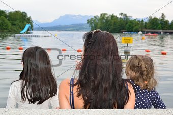 Mother and girls contemplating a lake