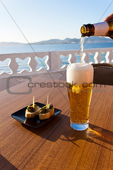 Pouring beer in a glass near the sea.
