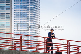 Portrait of asian office worker texting on mobile phone
