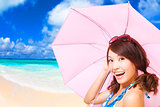 beauty woman holding a umbrella with beach background