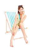 pretty sunshine girl smiling and sitting on a beach chair