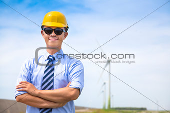 confident  young engineer standing with wind generator