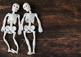 two funny skeleton on a black wooden board