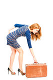 fragile slender girl lifts a heavy suitcase
