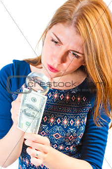 girl carefully considering the money through a magnifier