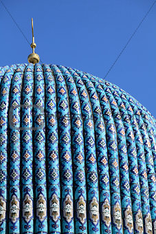 Tiled dome of a mosque with a golden crescent