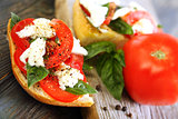 Ciabatta with tomatoes, cheese and basil close-up.