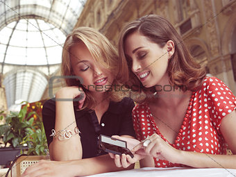 women look at message on mobile phone 