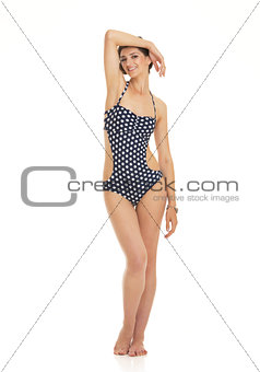 Full length portrait of relaxed young woman in swimsuit
