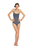 Full length portrait of smiling young woman in swimsuit